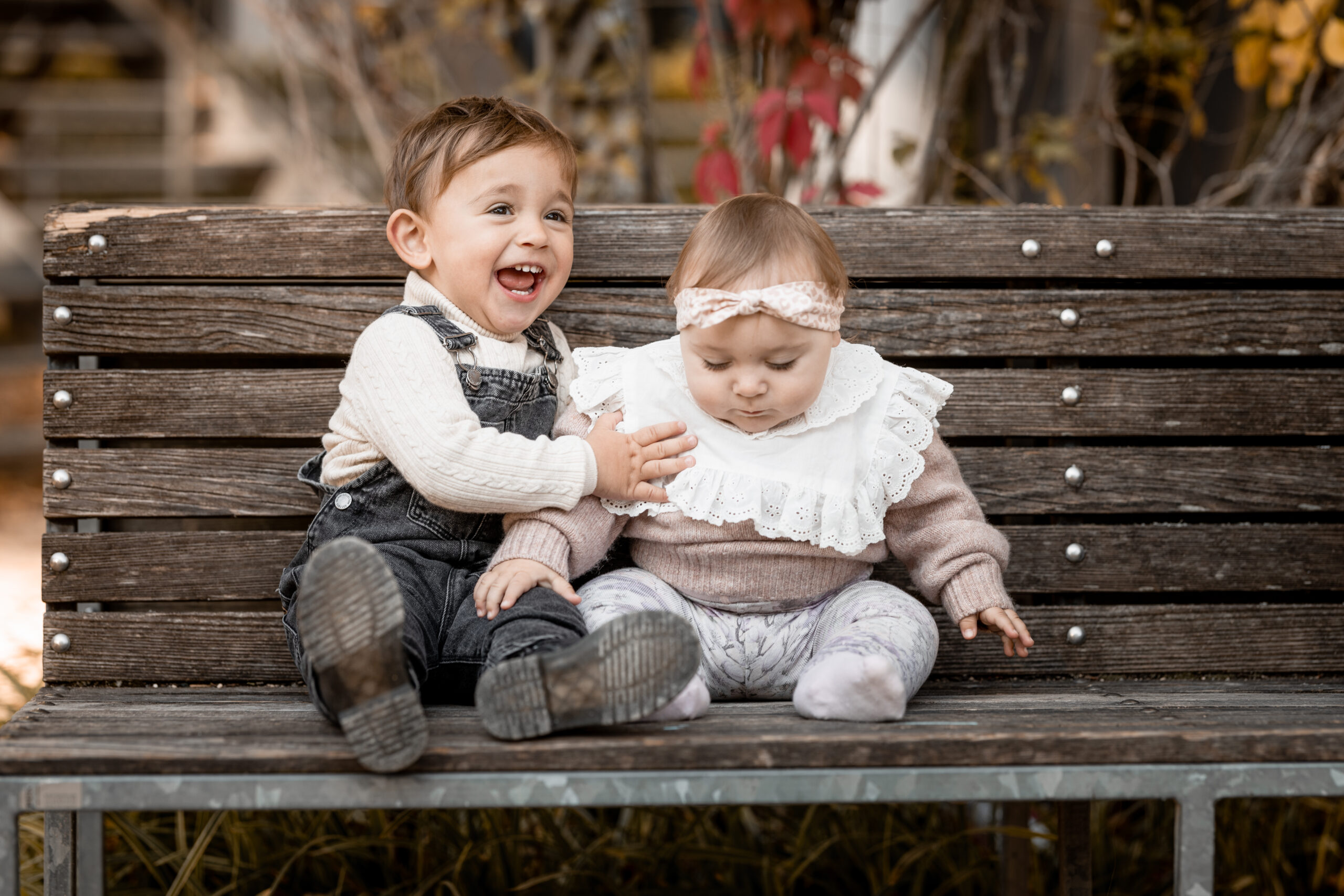 Geschwister die auf einer Bank sitzen beim Familien Fotoshooting